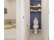 Comfortable bathroom with toilet, floating shelves, and blue accent wall at 4117 Galloway Park Dr, Charlotte, NC 28262