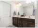 Bright bathroom with a double vanity, dark wood cabinets, and large mirror at 4117 Galloway Park Dr, Charlotte, NC 28262