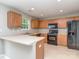 Functional kitchen with wood cabinetry, black appliances, and a breakfast bar at 4208 Everest Dr, Gastonia, NC 28054