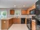 This kitchen features wood cabinets, black appliances, neutral countertops and a window with natural light at 4208 Everest Dr, Gastonia, NC 28054