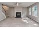 A spacious living room with a fireplace, neutral carpet, many windows, and a staircase to the second floor at 4208 Everest Dr, Gastonia, NC 28054