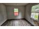 A bedroom has vinyl wood flooring, two windows, and is in need of repairs at 435 W Sharpe St, Statesville, NC 28677
