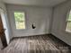 A bedroom has dark vinyl wood flooring and is in need of repairs at 435 W Sharpe St, Statesville, NC 28677