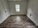 Bright bedroom with vinyl floors, a window, and a door at 435 W Sharpe St, Statesville, NC 28677