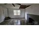 Living room featuring modern flooring, a gray brick fireplace, a window, and a damaged ceiling at 435 W Sharpe St, Statesville, NC 28677