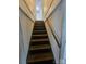 Staircase with wooden steps and a handrail against a white wall at 435 W Sharpe St, Statesville, NC 28677