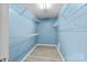 Walk-in closet with custom shelving, with wood-look flooring and painted in a light-blue hue at 4658 Cedar Rock Dr, Charlotte, NC 28273