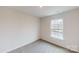 Bright bedroom with neutral carpet and walls, featuring a large window with natural light at 5058 Beargrass Dr, Dallas, NC 28034