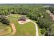 An aerial view of a stately brick home surrounded by lush greenery and a large pond on a sprawling estate at 534 N Ingleside Farm Rd, Iron Station, NC 28080