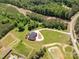 A beautiful aerial view of a well-maintained brick home with surrounding trees, a pond, and a long driveway at 534 N Ingleside Farm Rd, Iron Station, NC 28080