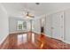 Spacious bedroom with gleaming hardwood floors, a ceiling fan, neutral paint, and natural light from the large window at 534 N Ingleside Farm Rd, Iron Station, NC 28080