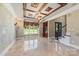 Elegant dining room with coffered ceiling, chandelier, travertine flooring, and custom wall details at 534 N Ingleside Farm Rd, Iron Station, NC 28080