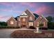 Stately two-story brick home with manicured landscaping and a circular driveway with fountain at 534 N Ingleside Farm Rd, Iron Station, NC 28080