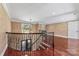 Hallway with hardwood floors and iron railing overlooking a staircase at 534 N Ingleside Farm Rd, Iron Station, NC 28080