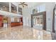 Open living space boasts tall ceilings, travertine floors, and large windows overlooking the backyard at 534 N Ingleside Farm Rd, Iron Station, NC 28080