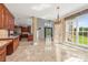 Open concept living area with travertine floors, wet bar, and bright windows to the outside at 534 N Ingleside Farm Rd, Iron Station, NC 28080