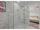 Modern bathroom boasts a glass shower, white subway tile, and a glimpse into the connecting bedroom at 5371 Davidson Rd, Davidson, NC 28036
