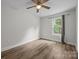 Bright, minimalist bedroom features a window with nature views and hardwood floors for a modern, clean look at 5371 Davidson Rd, Davidson, NC 28036