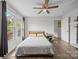 Comfortable bedroom boasts natural light and neutral tones, complemented by a ceiling fan and hardwood flooring at 5371 Davidson Rd, Davidson, NC 28036