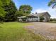Exterior view of home with metal carport, grass yard, and gravel driveway at 5371 Davidson Rd, Davidson, NC 28036