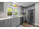 Well-lit kitchen features gray cabinets, stainless steel appliances, and double windows overlooking the yard at 5371 Davidson Rd, Davidson, NC 28036