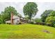 Spacious backyard with mature trees, a brick chimney, a deck and a screened in porch at 5604 Bethesda Ct, Charlotte, NC 28226