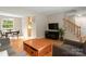 Open living room with hardwood floors, a staircase, comfortable seating, and access to the dining area at 5604 Bethesda Ct, Charlotte, NC 28226
