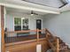 Comfortable covered front porch with wood flooring, railings, steps and bench seating at 6578 Bopre Ln, Denver, NC 28037