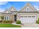 Charming home featuring brick and shingle accents, a two-car garage and manicured landscaping at 7036 Kitty Hawk Ln, Fort Mill, SC 29707