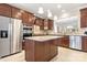 Stylish kitchen featuring a granite island, stainless steel appliances, and dark wood cabinets at 7036 Kitty Hawk Ln, Fort Mill, SC 29707