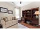 Cozy living room with a comfortable sofa, built-in shelving, and hardwood floors at 7036 Kitty Hawk Ln, Fort Mill, SC 29707