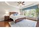 Spacious main bedroom with hardwood floors, a ceiling fan, large windows, and a decorative accent wall at 7036 Kitty Hawk Ln, Fort Mill, SC 29707