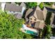 Aerial view of a home with a backyard featuring a pool, hot tub, deck, screened-in porch, and mature trees at 7428 Edenbridge Ln, Charlotte, NC 28226