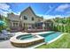 The backyard has a stone-trimmed hot tub, in-ground pool, wooden deck, and screened-in porch at 7428 Edenbridge Ln, Charlotte, NC 28226