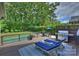 Backyard deck with grill, lounge chairs, and pool surrounded by greenery at 7428 Edenbridge Ln, Charlotte, NC 28226