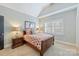 Cozy bedroom with vaulted ceiling, a wood bed frame, and a bright window at 7428 Edenbridge Ln, Charlotte, NC 28226