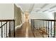 Second floor hallway featuring hardwood floors and decorative railing overlooking entry foyer at 7428 Edenbridge Ln, Charlotte, NC 28226