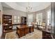 Elegant home office with custom millwork, plantation shutters, built-in bookcase and dark wood floors at 7428 Edenbridge Ln, Charlotte, NC 28226