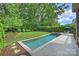 A backyard oasis featuring a rectangular pool, hot tub, manicured lawn, and privacy landscaping at 7428 Edenbridge Ln, Charlotte, NC 28226