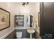 Charming powder room features stylish wallpaper, pedestal sink, and elegant chandelier at 7428 Edenbridge Ln, Charlotte, NC 28226