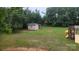 View of a large backyard with mature trees, a storage shed, and a playset at 8282 Park Edwards Rd, Kannapolis, NC 28081