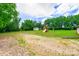 Expansive backyard featuring mature trees, a storage shed, and playset with slide and swings at 8282 Park Edwards Rd, Kannapolis, NC 28081