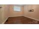 A clean, minimalist bedroom featuring hard wood floors and a window providing ample natural light at 8282 Park Edwards Rd, Kannapolis, NC 28081