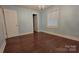 A bedroom with hardwood floors, featuring a closet door and a window with natural light at 8282 Park Edwards Rd, Kannapolis, NC 28081