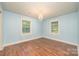 A bright bedroom with hardwood floors, two windows, and a decorative chandelier at 8282 Park Edwards Rd, Kannapolis, NC 28081