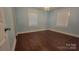 A bright bedroom with hardwood floors, two windows, and a decorative chandelier at 8282 Park Edwards Rd, Kannapolis, NC 28081