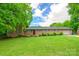 Charming brick home with lush green lawn, mature trees, and inviting curb appeal on a sunny day at 8282 Park Edwards Rd, Kannapolis, NC 28081