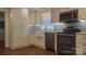 View of the open kitchen with white cabinets, stainless appliances, marble countertops, and a blue subway tile backsplash at 8282 Park Edwards Rd, Kannapolis, NC 28081
