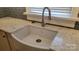 Close-up of the modern kitchen with a farmhouse sink, marble countertops, stylish faucet, and charming blue backsplash at 8282 Park Edwards Rd, Kannapolis, NC 28081