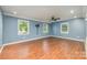 Bright living room with blue walls, hardwood floors, and large windows for natural light at 8282 Park Edwards Rd, Kannapolis, NC 28081